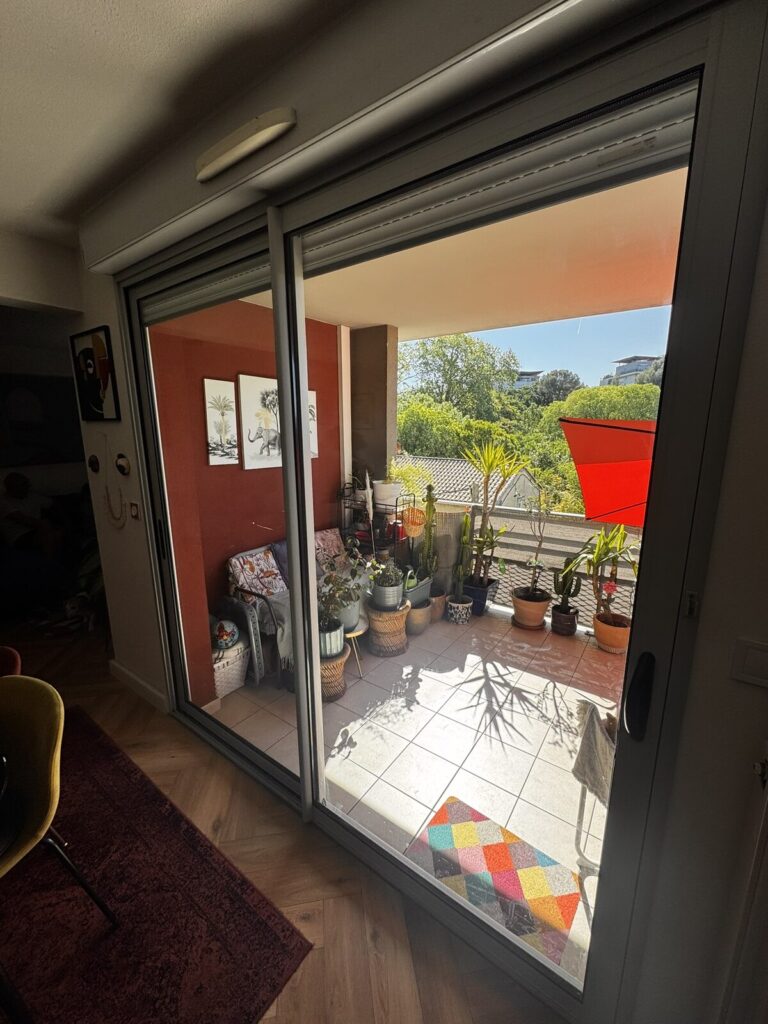 Baie vitrée coulissante vue depuis le séjour, réalisation Les Alchimistes du Bâtiment