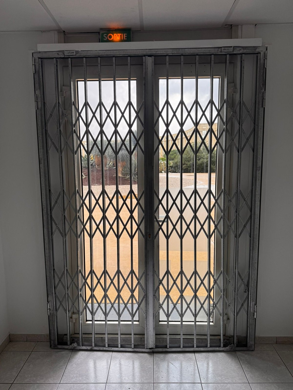 Grille de sécurité extensible installée sur une porte-fenêtre par un serrurier