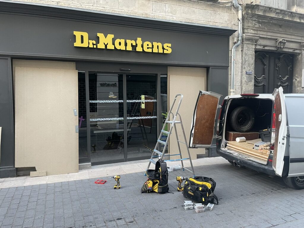 Devanture d'un magasin Dr Martens à Montpellier protégée par des panneaux après effraction