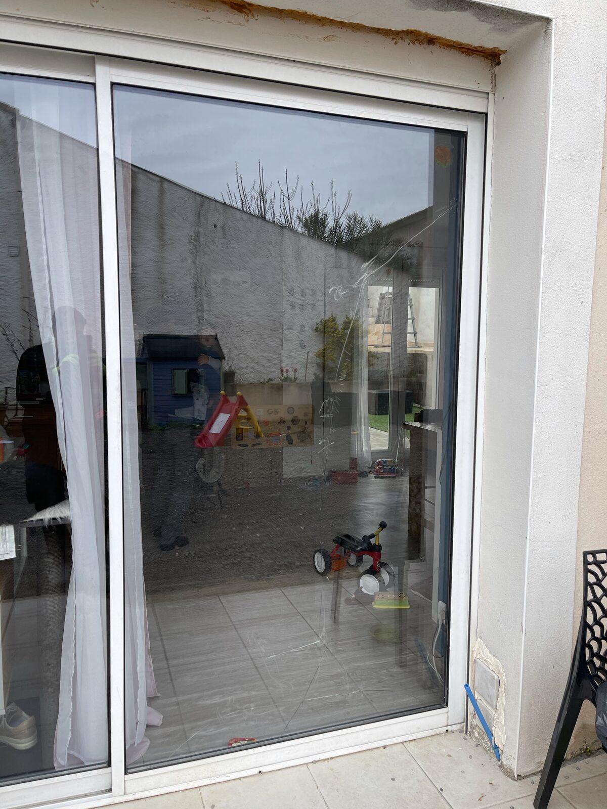 Baie vitrée coulissante d'une maison avant remplacement du vitrage