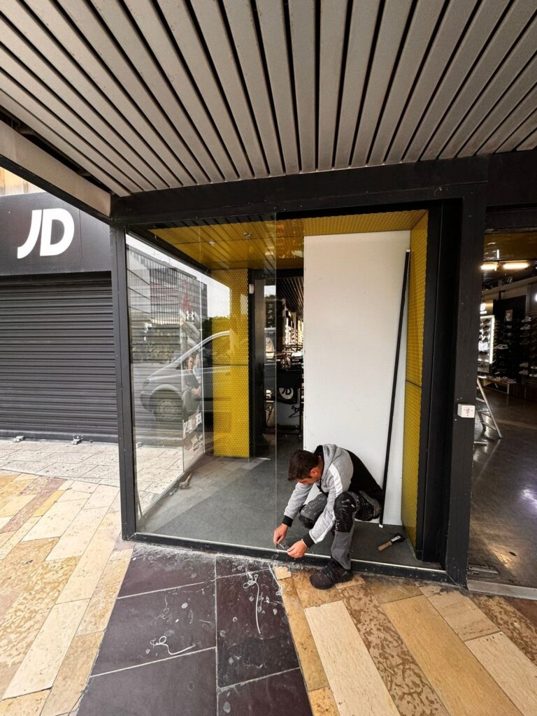 Pose d'un vitrage sur le sas d'entrée d'un magasin