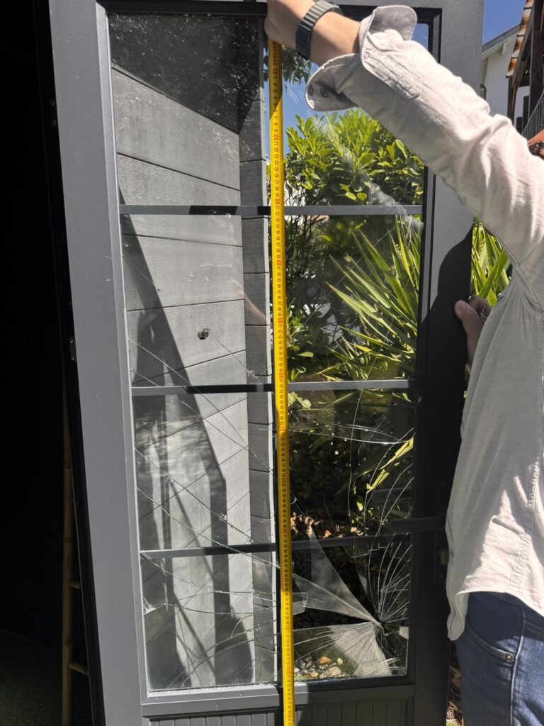 Prise de mesure au mètre d'un vitrage sur un balcon