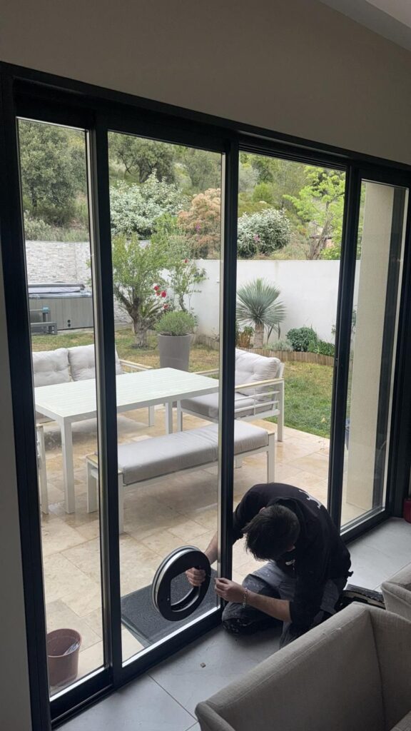 Pose du joint d'une baie vitrée coulissante donnant sur un jardin